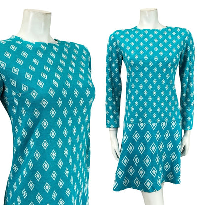 Mannequin wears a 60s blue and white mod diamond print dropped waist long sleeve midi dress. 