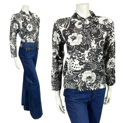 Mannequin wears a 60s 70s black and white floral printed dagger collar shirt with blue flared jeans. 