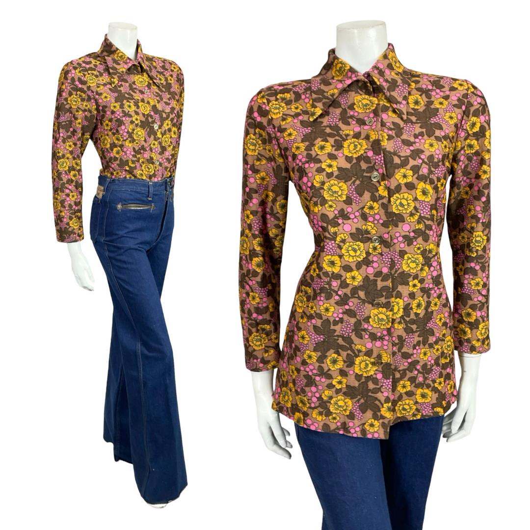Mannequin wears a 60s 70s brown pink and yellow floral print dagger collar shirt with blue flared jeans. 