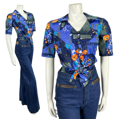 Mannequin wears a blue and orange floral open dagger collar short sleeve tie waist cropped shirt with blue flared jeans. 