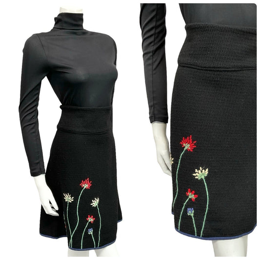 Mannequin wears a 60s 70s black floral embroidered knitted mini skirt with a black turtleneck