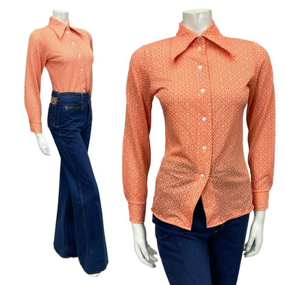 Mannequin wears a 60s 70s orange and white geometric tile print dagger collar shirt with blue flared jeans 
