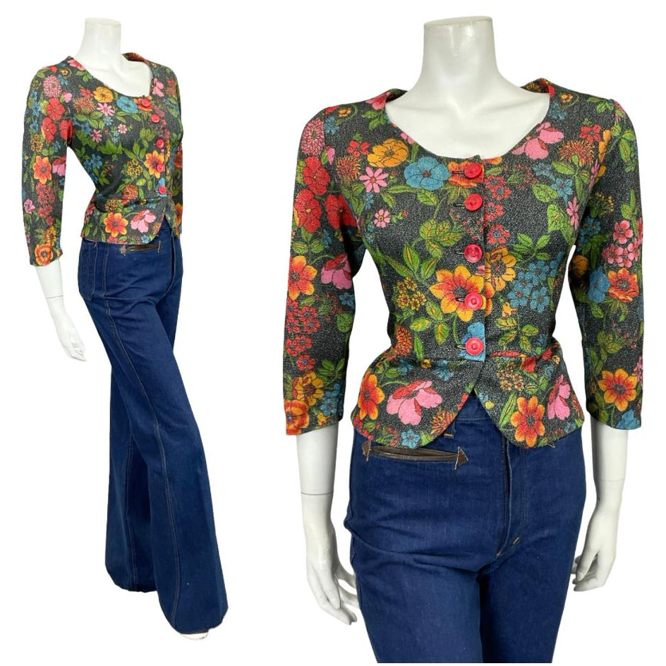 Mannequin wears a 60s 70s glittery black floral lurex peplum blouse with blue flared jeans 