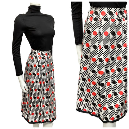 Mannequin wears a 60s white red and black geometric mod dotty striped pleated midi skirt with a black turtleneck