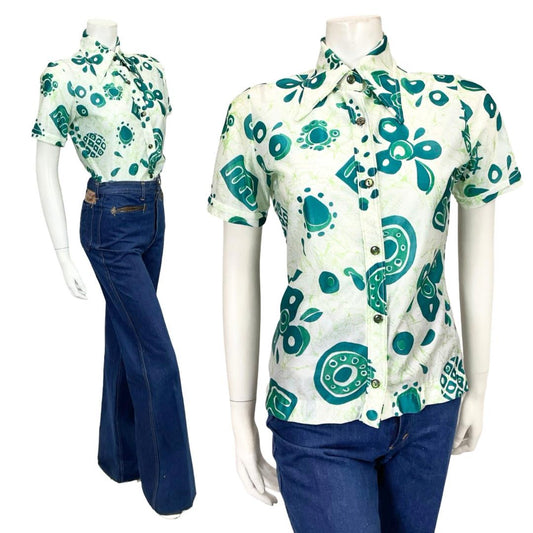 Shrinking Violets Vintage 60s 70s white and green psychedelic geometric short sleeved dagger collar shirt n a white mannequin wearing blue flared jeans 