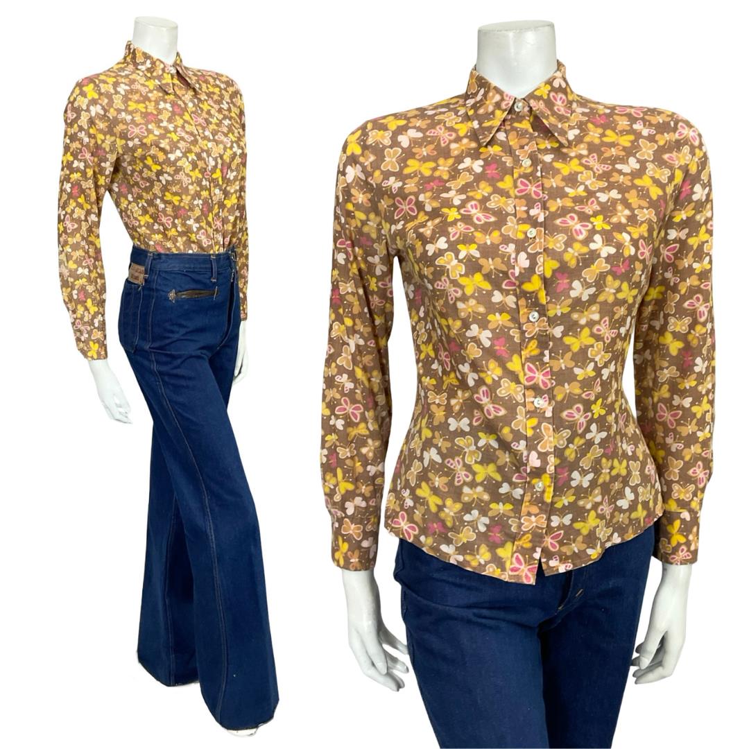 Shrinking Violets Vintage 60s 70s brown pink and yellow butterfly print shirt on a white mannequin wearing blue flared jeans 