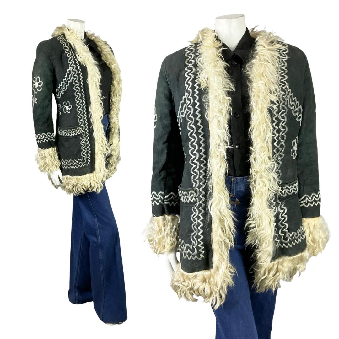 Shrinking Violets Vintage black suede cream shearling with floral embroidery on a mannequin wearing blue flared jeans 