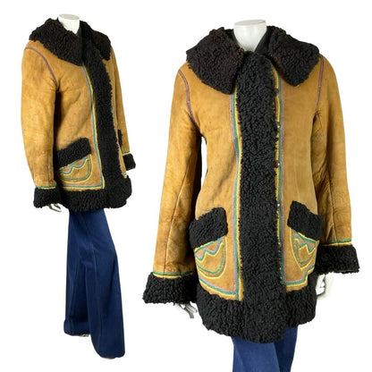 Shrinking Violets Vintage 60s 70s brown suede shearling with rainbow trim embroidery on a white mannequin wearing blue flared jeans