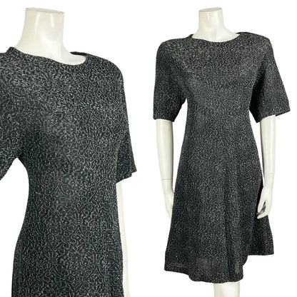 Mannequin wears a black and silver lurex wavy print short sleeve mod party dress. 