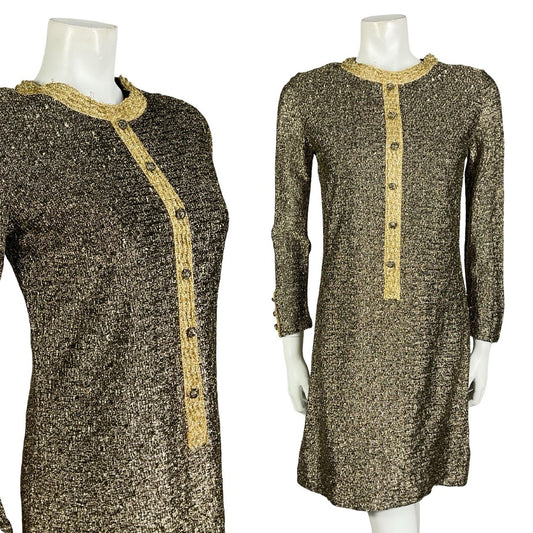 Mannequin wears a glittery gold long sleeve ringer shift dress with decorative button down front. 