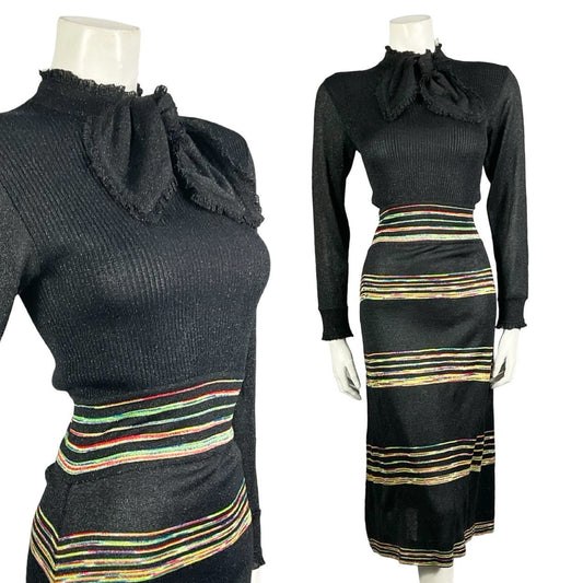 Mannequin wears a vintage 60s 70s black glittery lurex knitted midi dress with a pussybow neck tie and rainbow horizontal stripe print.