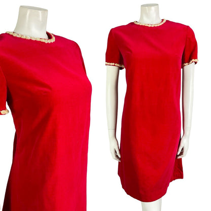 Mannequin wears a bright red velvet short sleeve vintage 60s mod dress with a cream sequin trim on the neck and sleeves. 