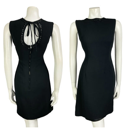 Mannequin wears a vintage 60s 70s mod little black mini dress with a keyhole back and sequin trim. 