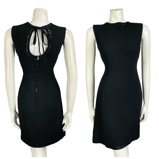 Mannequin wears a vintage 60s 70s mod little black mini dress with a keyhole back and sequin trim. 