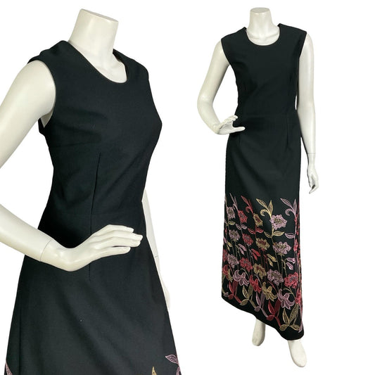Mannequin wears a black sleeveless maxi dress with gold, red and pink floral embroidery around the hemline.