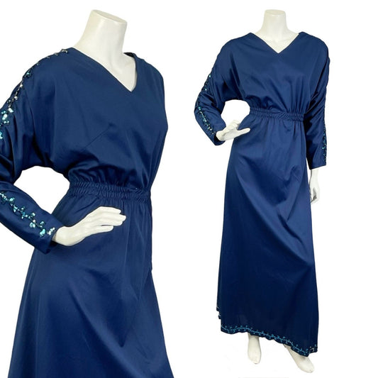 Mannequin wears a navy blue vintage blouson maxi dress with ruched sleeves and sequin detail on the sleeves. 