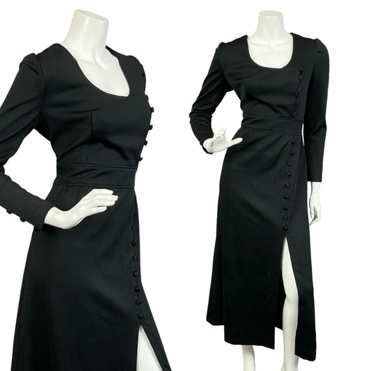 Mannequin wears a vintage 60s 70s all black long sleeve maxi dress, with an empire waist and side slit. 