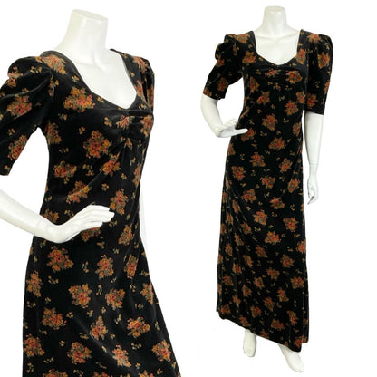 Mannequin wear a black, red and green floral printed velvet maxi dress with short mutton sleeves. 