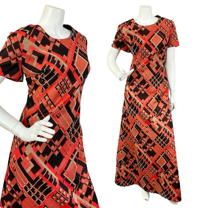 Mannequin wears a black, red and gold geometric lurex short sleeve maxi dress. 