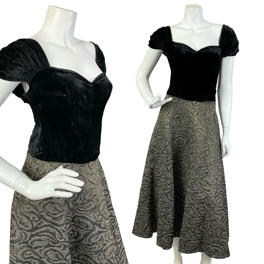 Mannequin wears a vintage 60s evening maxi dress with a black velvet cap sleeve sweetheart bodice, and bronze swirl damask skirt. 