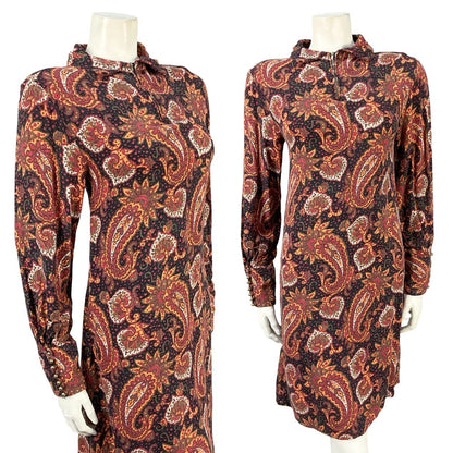 Mannequin wears a psychedelic mandala print shift dress with long sleeves in black, red and beige. 
