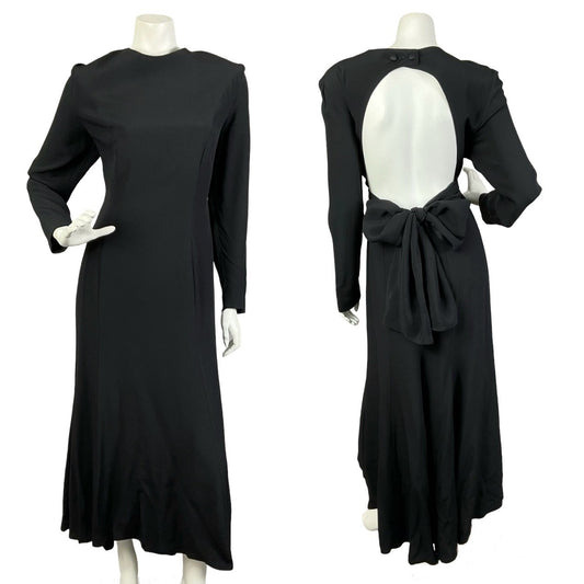 Mannequin wears a vintage 70s 80s all-black, backless long sleeve maxi dress with a bow tie at the back of the waist. 
