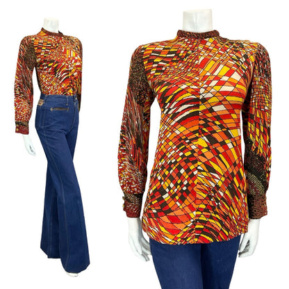 mannequin wears blue flared jeans with a psychedelic brown, orange, red and white geometric long sleeve top
