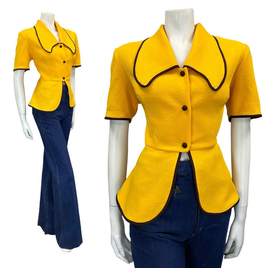 Mannequin wears blue flared jeans and a yellow dog ear 70s vintage top with short sleeves and a peplum hem.