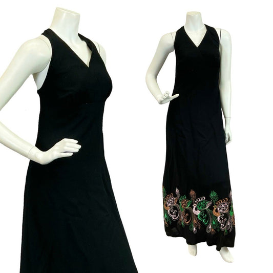 Mannequin wears a 70s black velvet halter maxi dress with purple and green peacock embroidery at the hemline. 