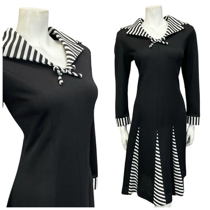 Mannequin wears a black and white 60s 70s long sleeve sailor collar midi dress with godet flared hemline. 