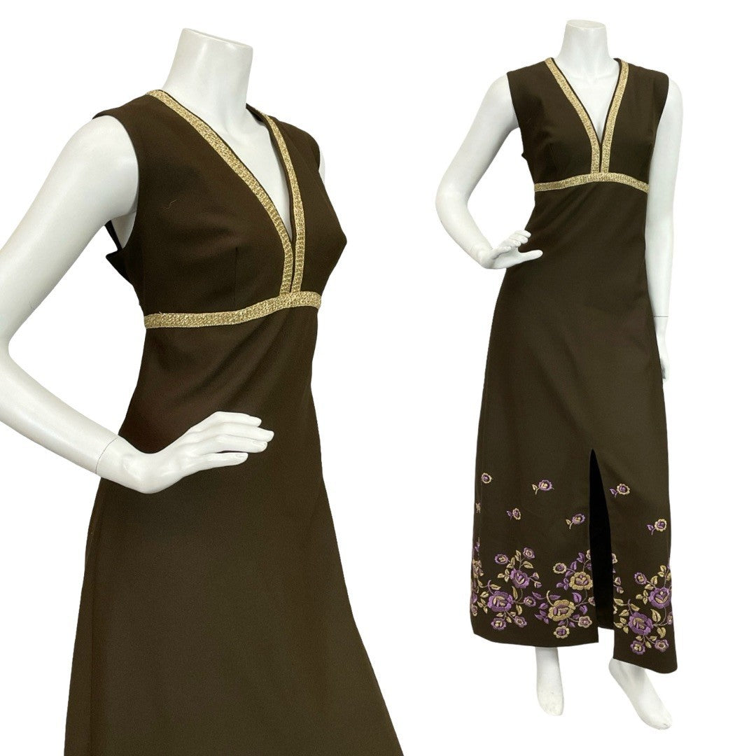 Mannequin wears a 60s 70s brown and gold sleeveless empire maxi dress with floral embroidery at the hemline. 