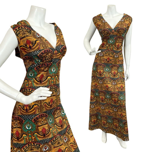 Mannequin wears a 60s 70s sleeveless lurex empire maxi dress printed with an Egyptian geometric pattern. 