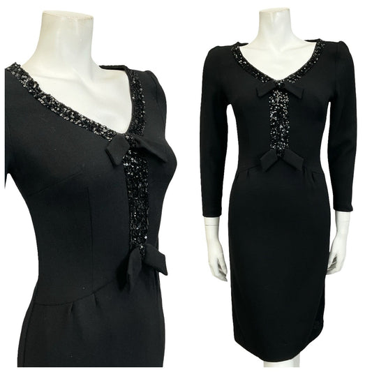 Mannequin wears a 60s mod black pure wool long sleeve wiggle dress with a sequin and bow V - neckline