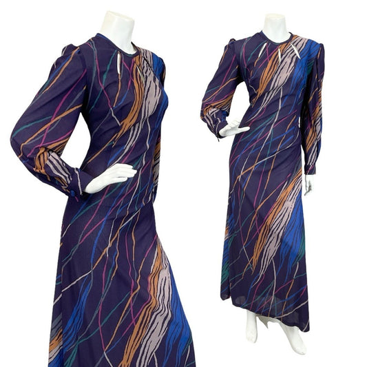 Mannequin wears a 60s 70s purple yellow and blue long sleeve maxi dress with a stripe print and keyhole neckline. 