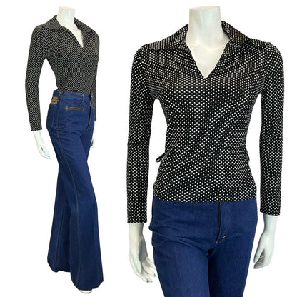 mannequin wears blue flared jeans and a polka dot black and white long sleeve wing collar top