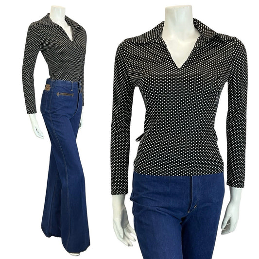 mannequin wears blue flared jeans and a polka dot black and white long sleeve wing collar top