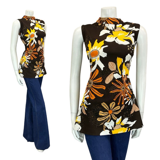 mannequin wears blue flared jeans with a brown tunic patterned with orange and yellow flowers