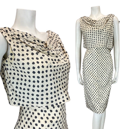 mannequin wears a cream and black dotty Pierre Balmain blouson midi dress